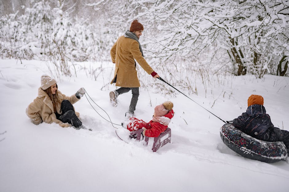 A photo of children playing in the snow with warm winter clothing.